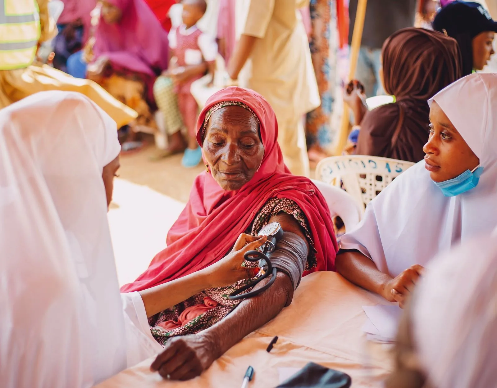 Black woman receives a health screening at a community outreach table offering dementia resources
